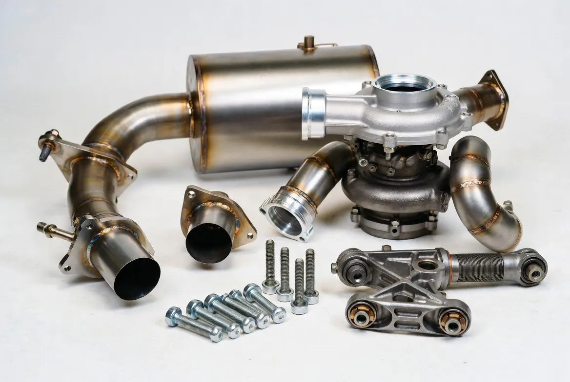 5-Axis CNC milled, metal 3D printed and investment cast titanium alloy parts including exhaust systems, fasteners, turbocharger components and performance suspension parts in Grade 2 and Ti-6Al-4V with metallic gray finish on clean white background